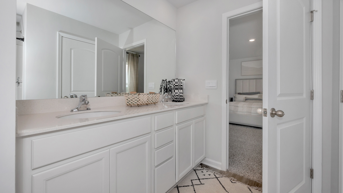 Primary bath with painted cabinets and quartz countertops