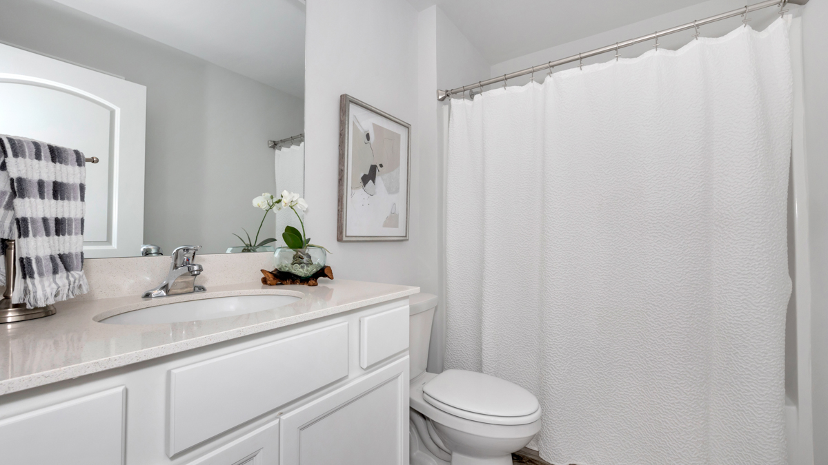 Secondary bathroom with painted cabinets and quartz countertops