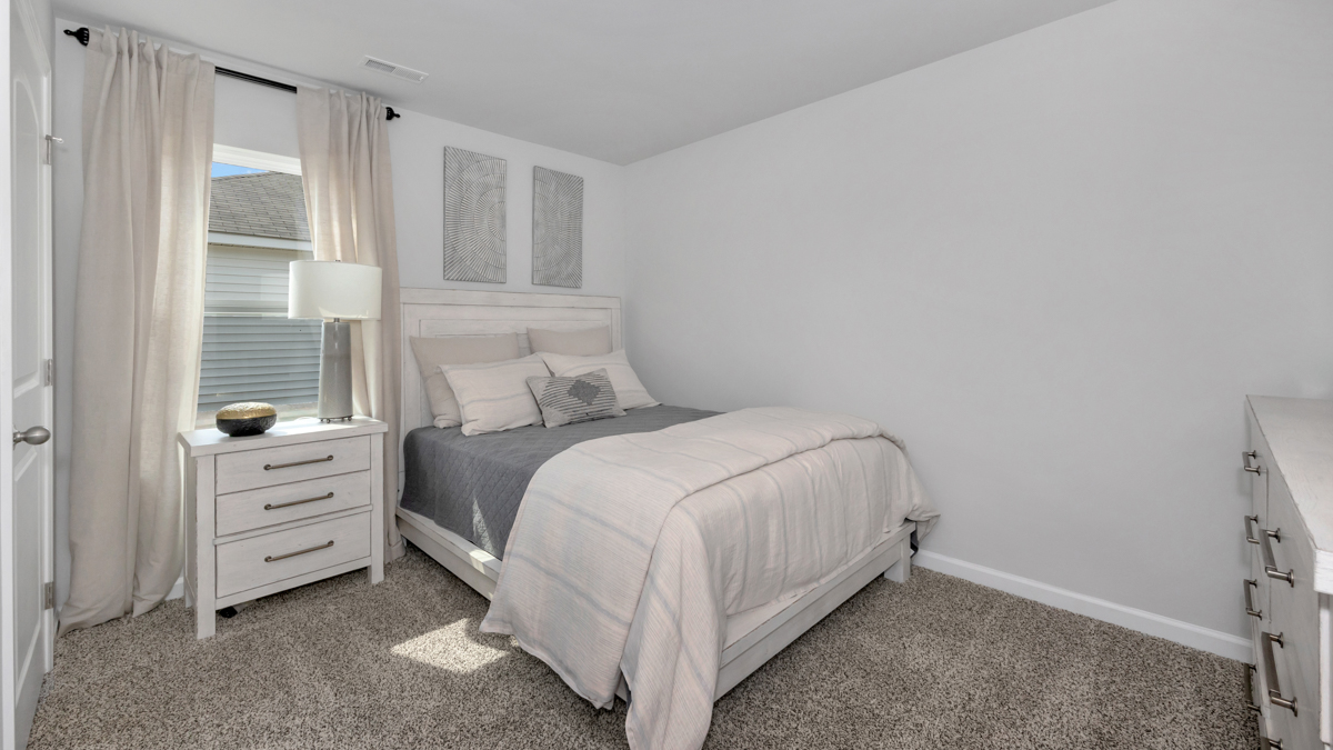 Secondary bedroom with carpet and window