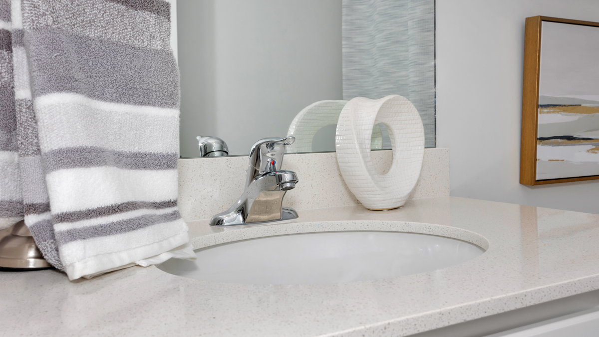 Secondary bathroom with painted cabinets and quartz countertops