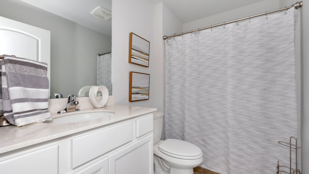 Secondary bathroom with painted cabinets and quartz countertops