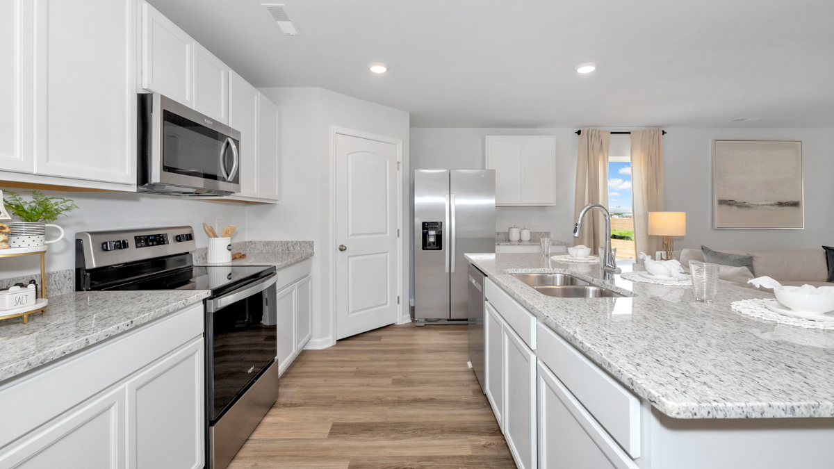 Kitchen island with painted cabinets and stainless steel appliances