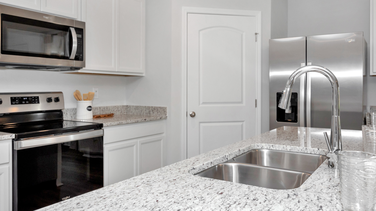 Kitchen sink with granite surround and stainless steel appliances