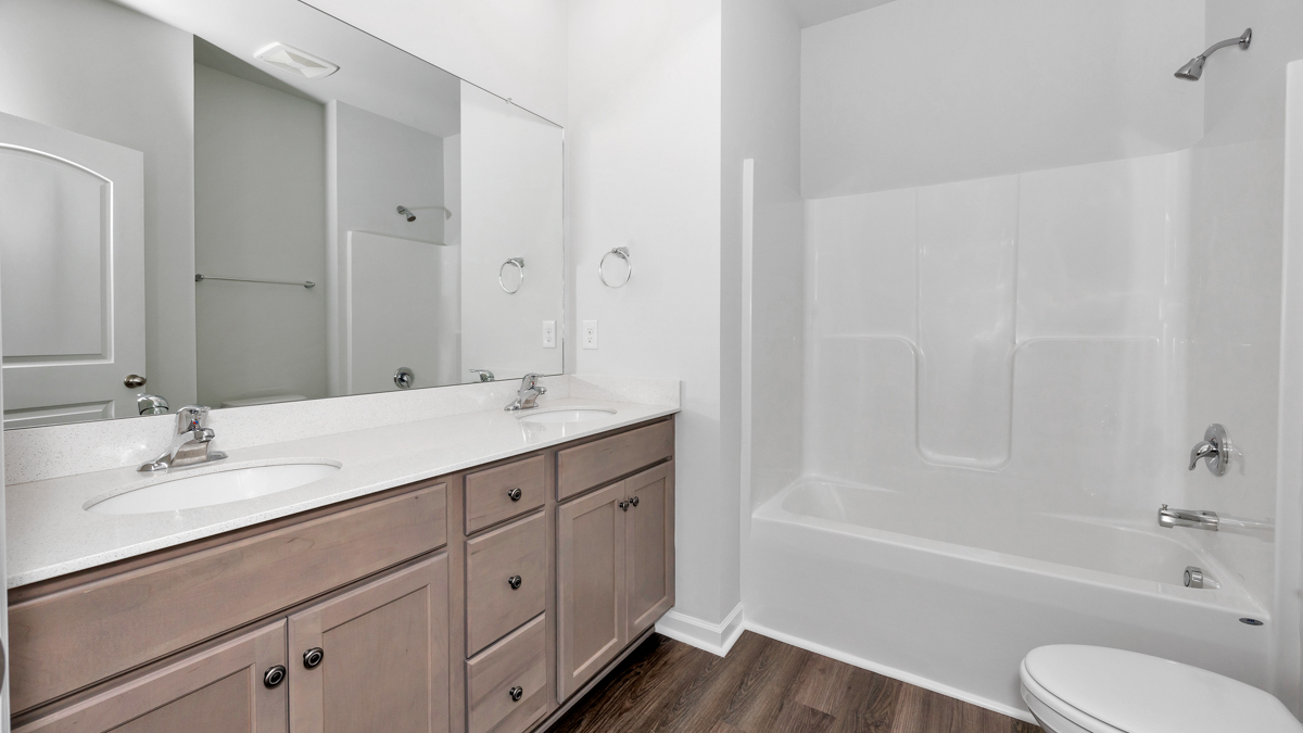 Secondary bathroom with stained cabinets and quartz countertops