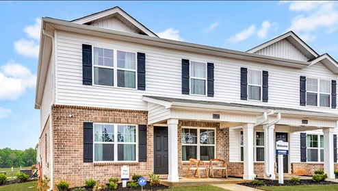 two story townhome with vinyl and brick and two car garage