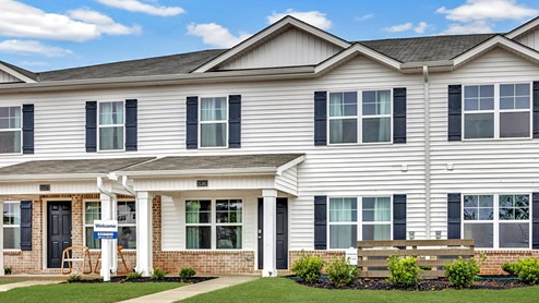 two story townhome with vinyl and brick and two car garage