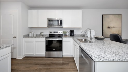 Kitchen island with painted cabinets and stainless steel appliances