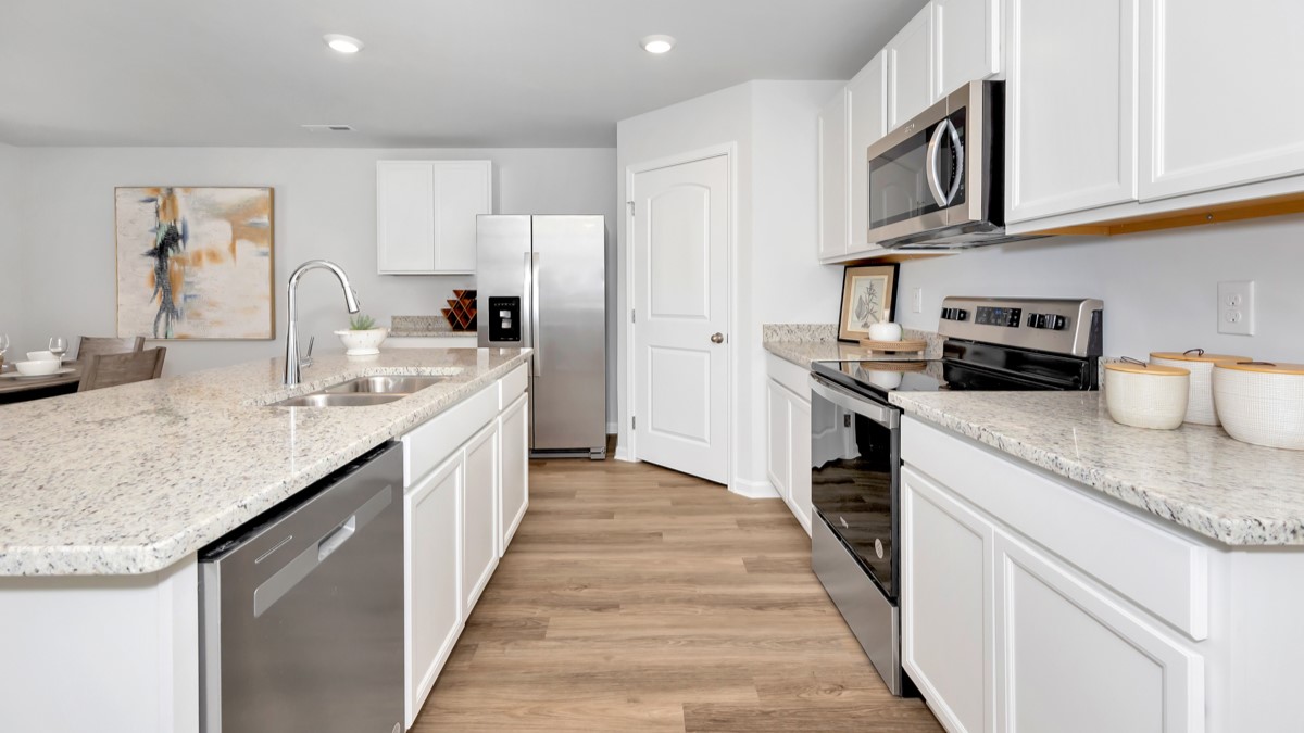 Kitchen island with painted cabinets and stainless steel appliances