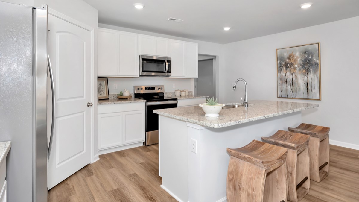 Kitchen island with painted cabinets and stainless steel appliances