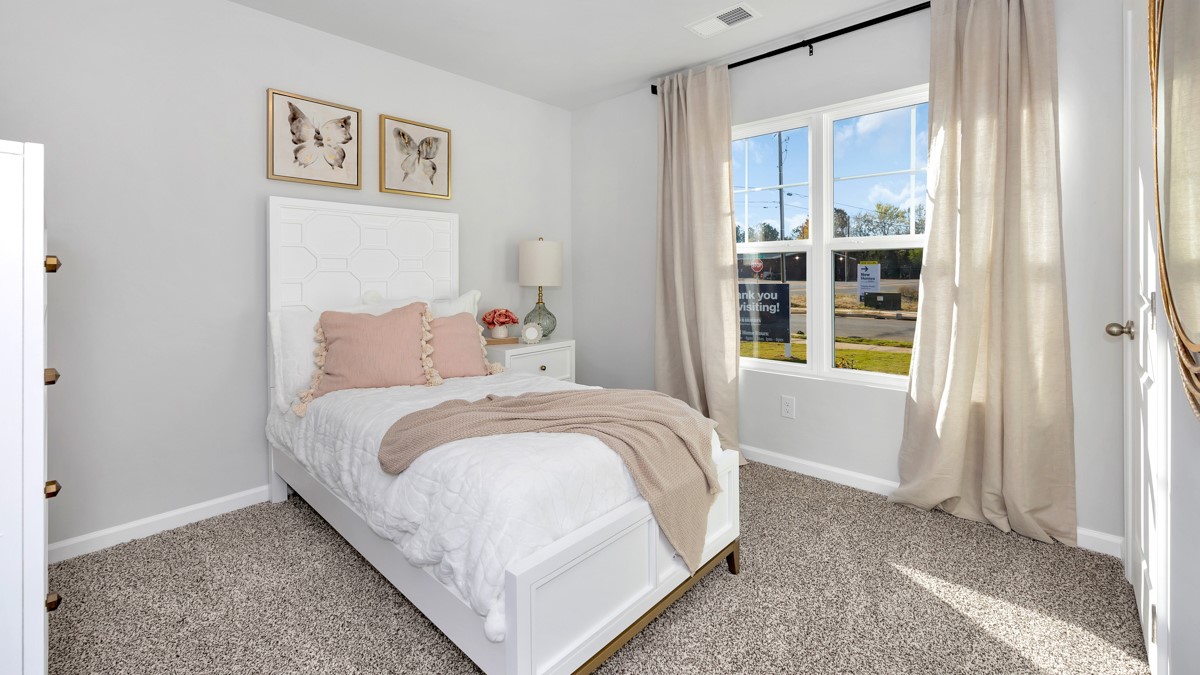 Secondary bedroom with carpet and window