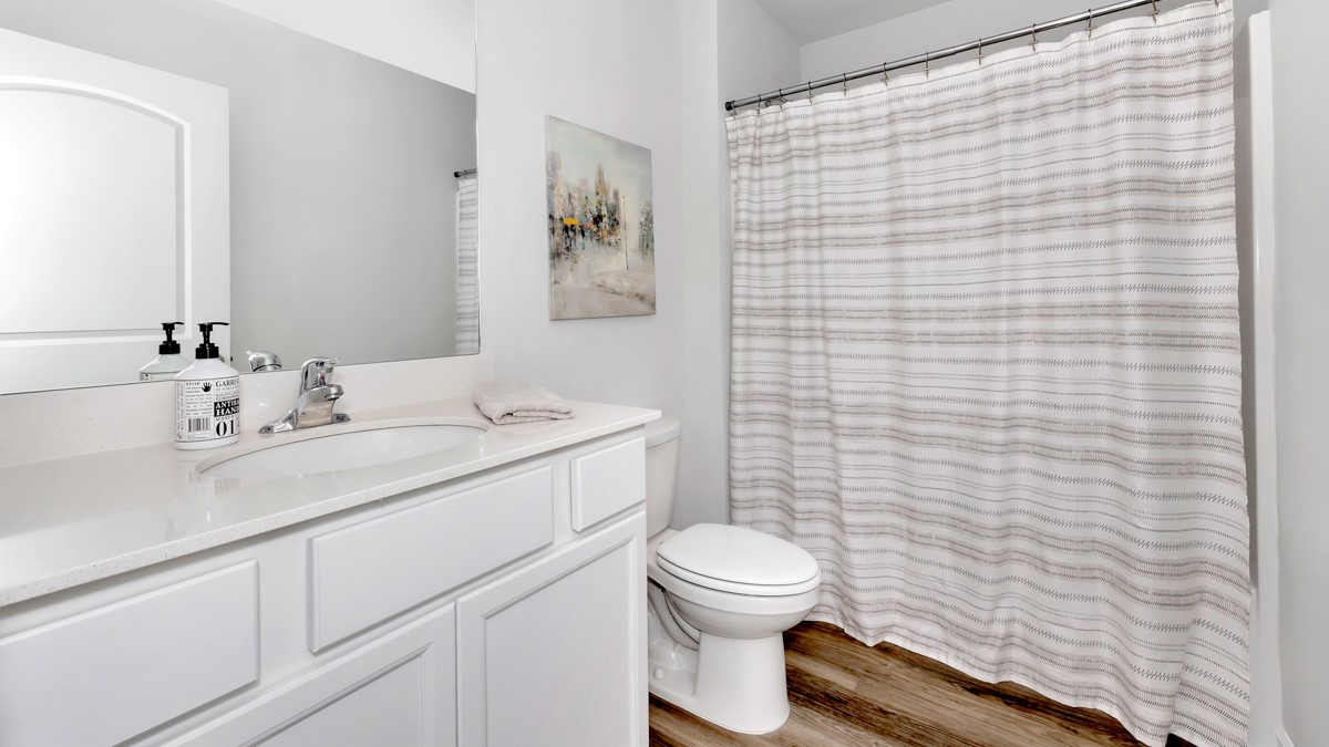 Secondary bathroom with painted cabinets and quartz countertops