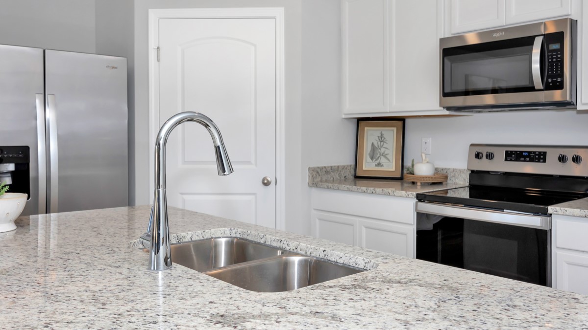 Kitchen sink with granite surround and stainless steel appliances