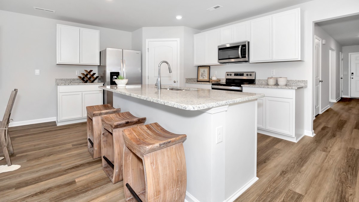 Kitchen island with painted cabinets and stainless steel appliances