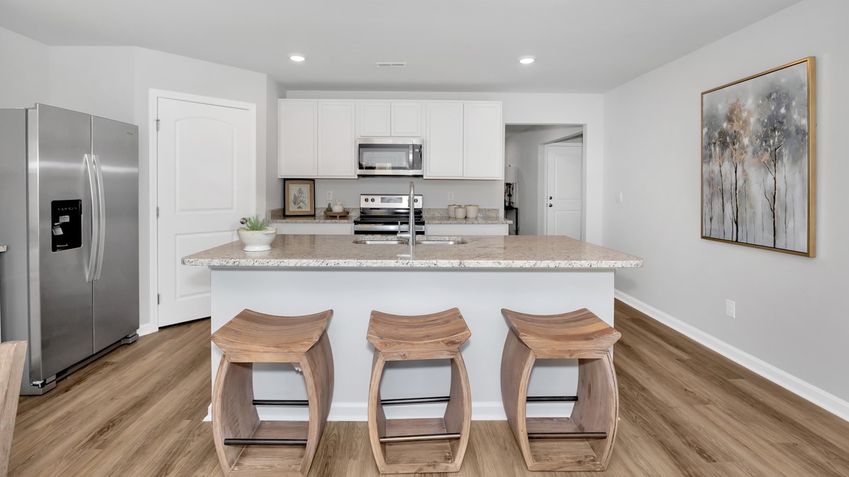 Kitchen island with painted cabinets and stainless steel appliances
