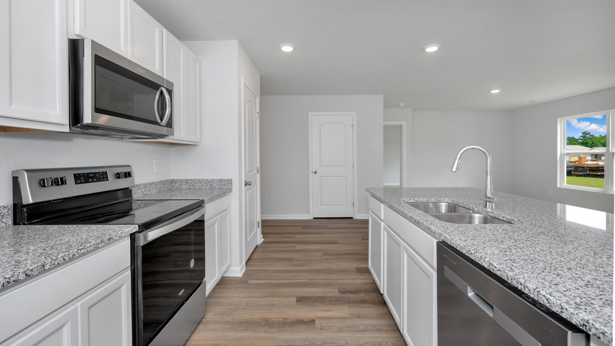Kitchen island with painted cabinets and stainless steel appliances