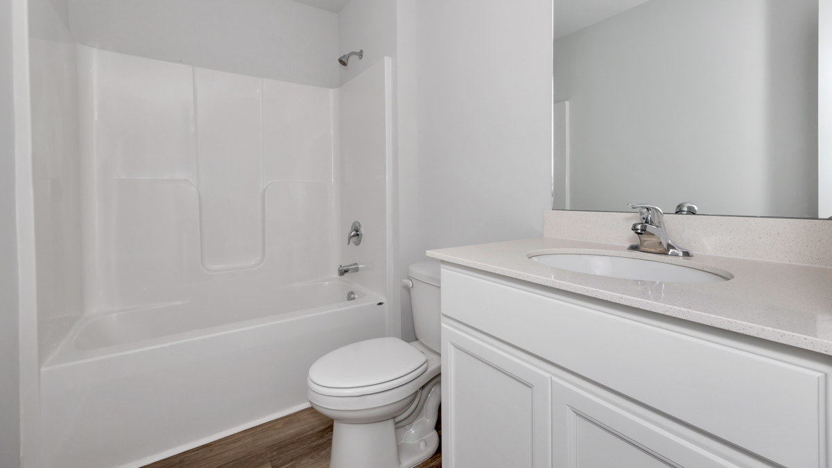 Secondary bathroom with painted cabinets and quartz countertops
