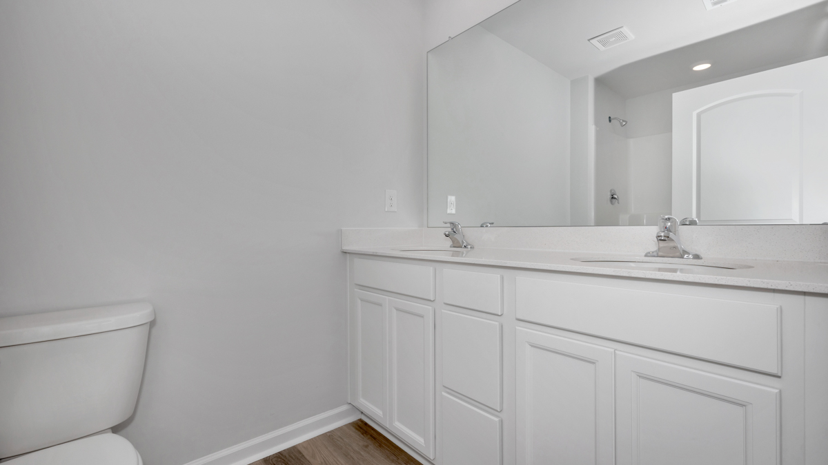 Primary bath with painted cabinets and quartz countertops
