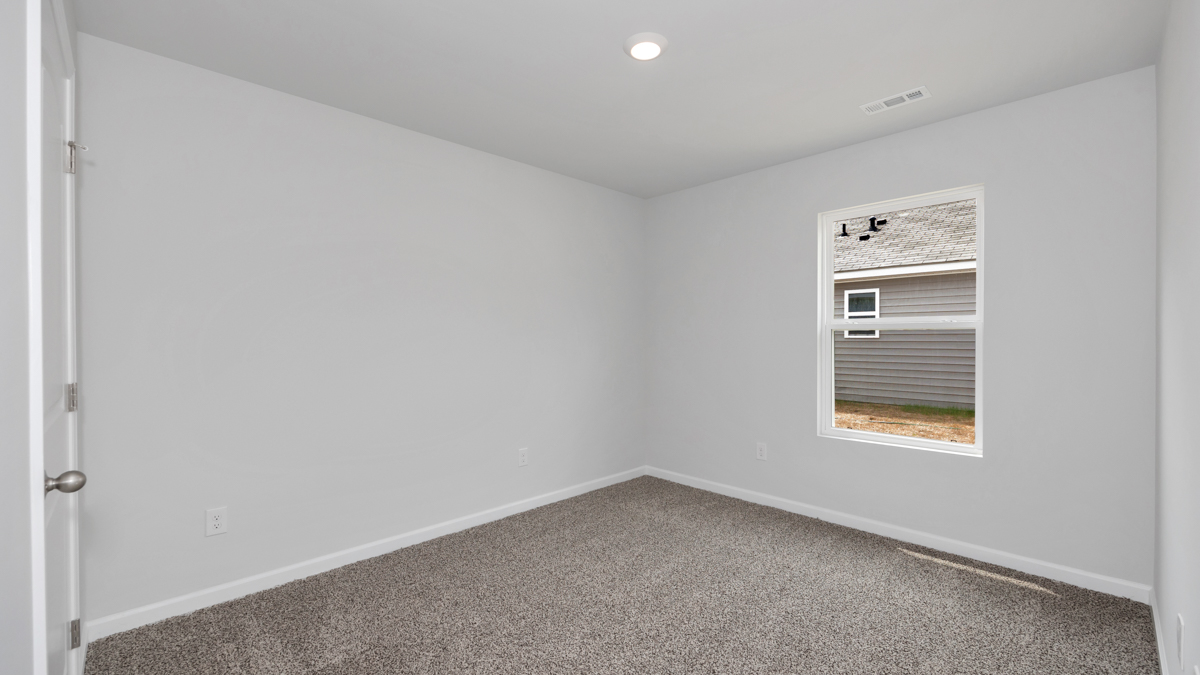 Secondary bedroom with carpet and window