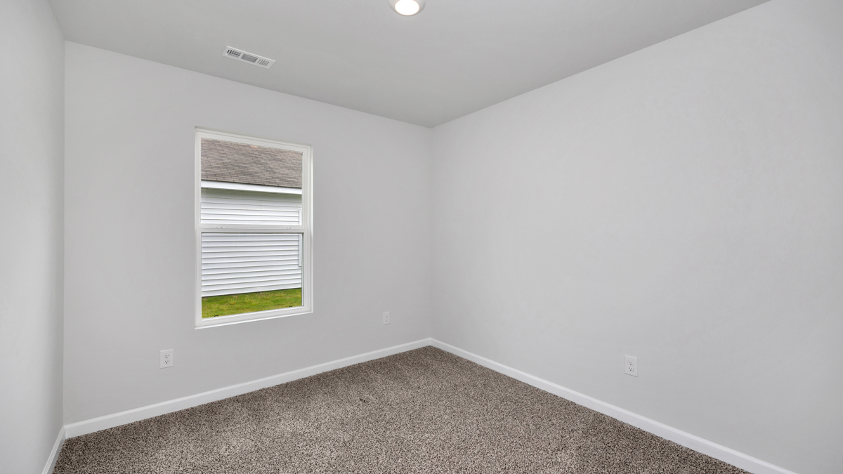 Secondary bedroom with carpet and window