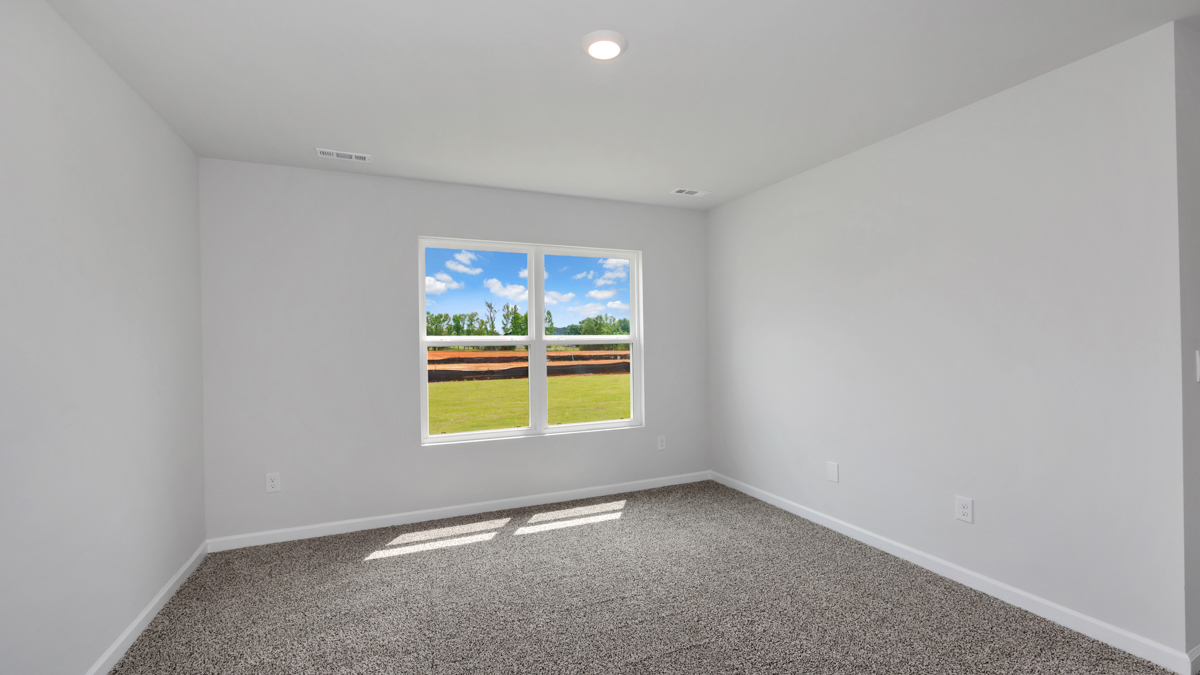 Secondary bedroom with carpet and window
