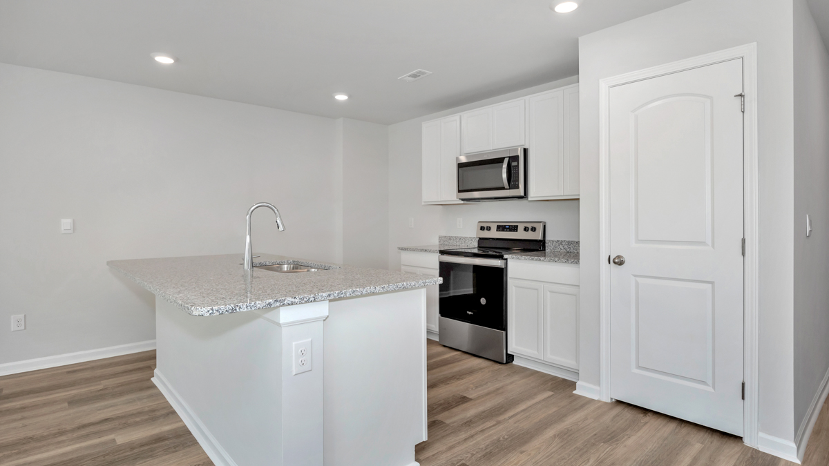 Kitchen island with painted cabinets and stainless steel appliances