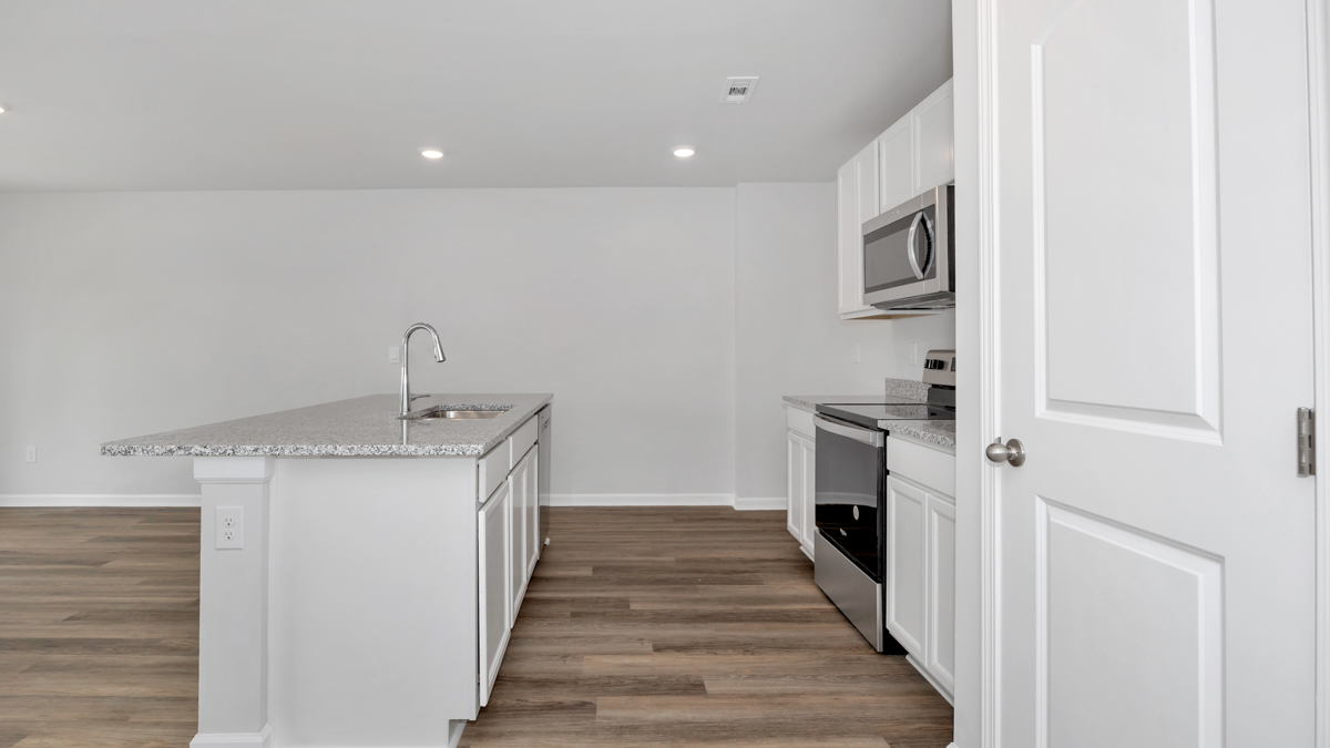 Kitchen island with painted cabinets and stainless steel appliances