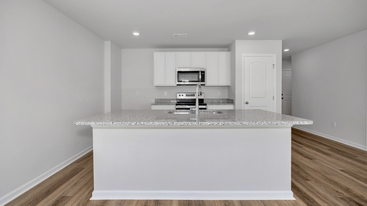 Kitchen island with painted cabinets and stainless steel appliances