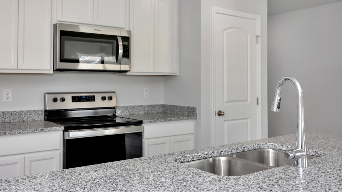 Kitchen sink with granite surround and stainless steel appliances