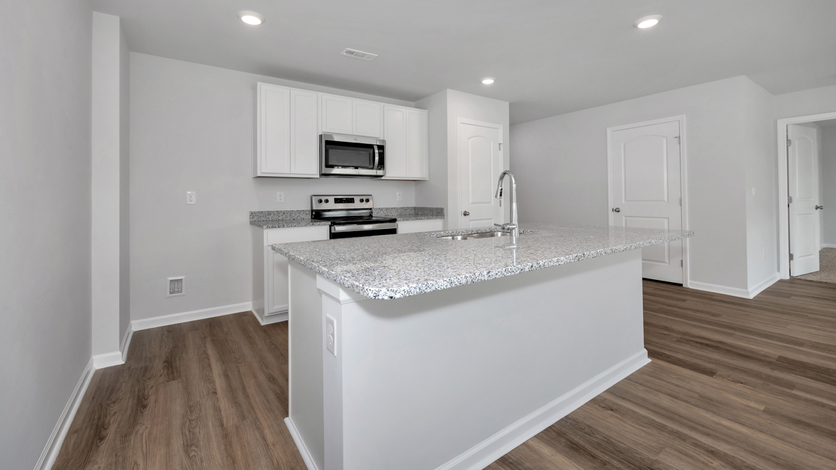 Kitchen island with painted cabinets and stainless steel appliances