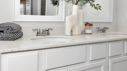Primary bath with painted cabinets and quartz countertops