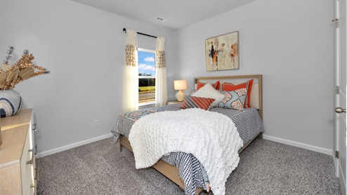 Secondary bedroom with carpet and window