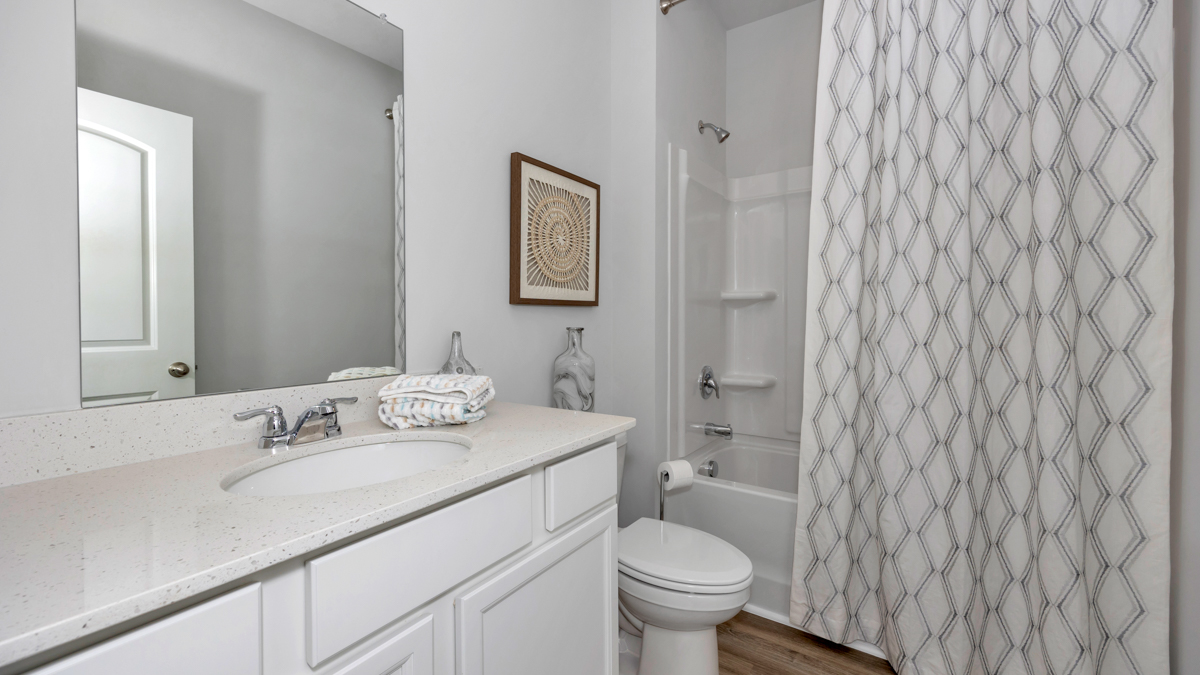 Secondary bathroom with painted cabinets and quartz countertops