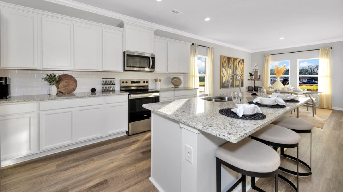 Kitchen island with painted cabinets and stainless steel appliances