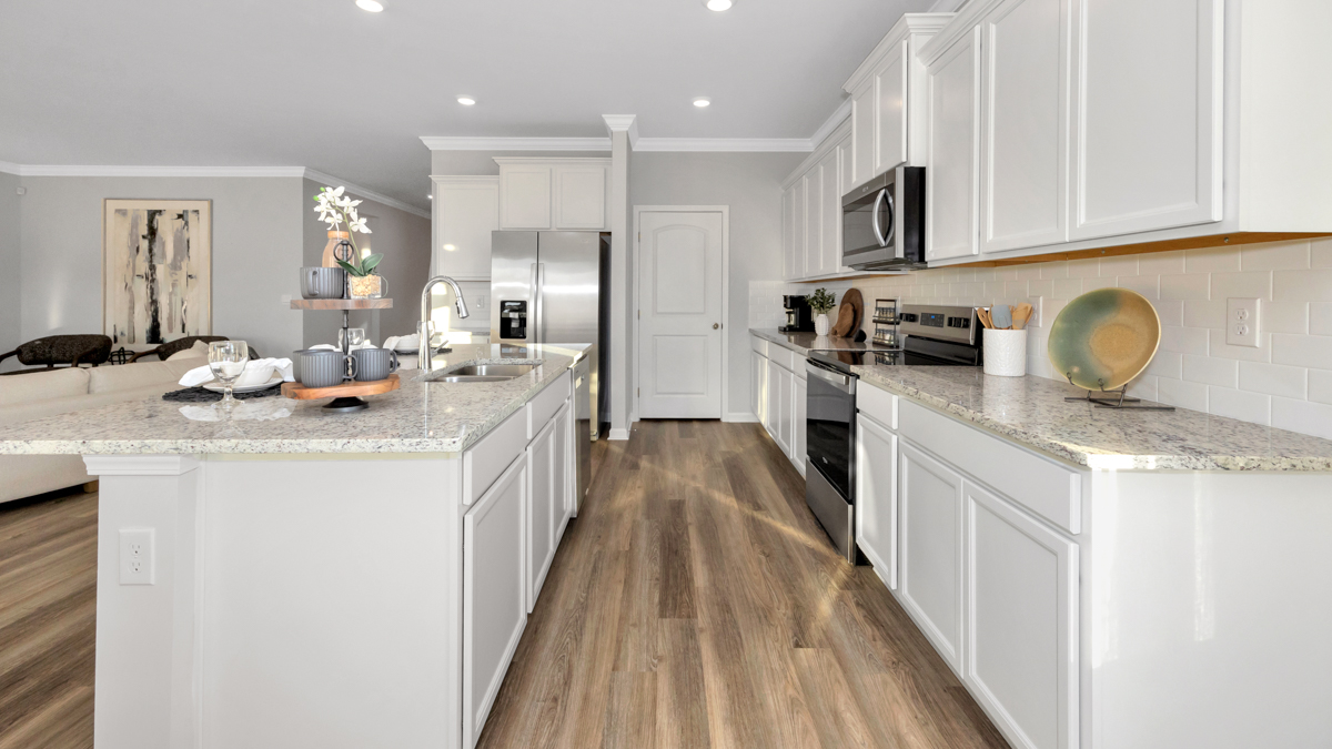 Kitchen island with painted cabinets and stainless steel appliances