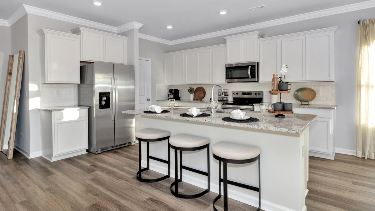 Kitchen island with painted cabinets and stainless steel appliances