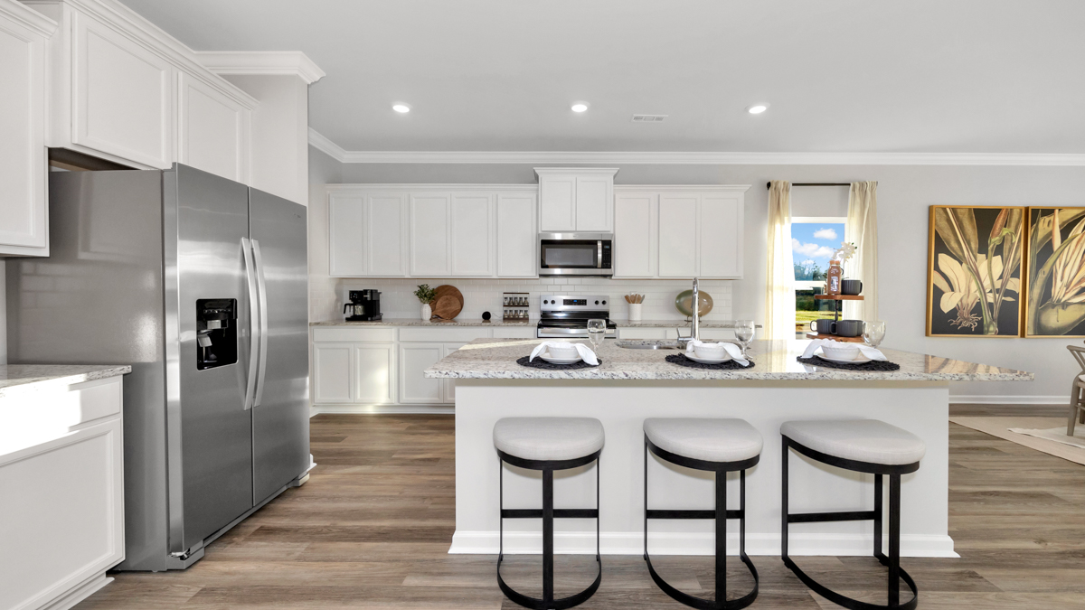 Kitchen island with painted cabinets and stainless steel appliances
