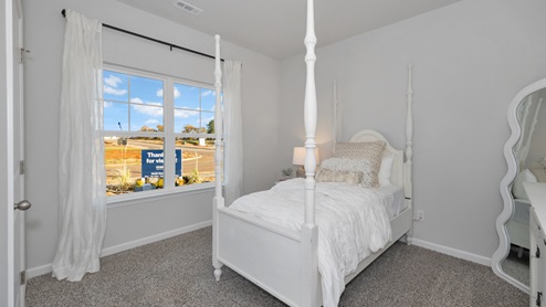 Secondary bedroom with carpet and window
