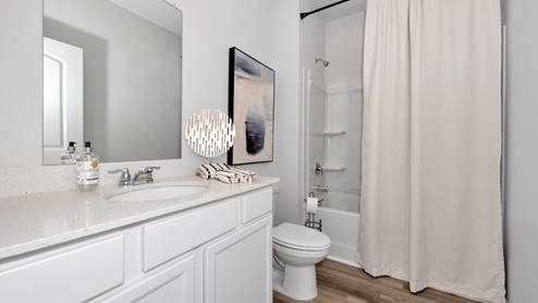 Secondary bathroom with painted cabinets and quartz countertops