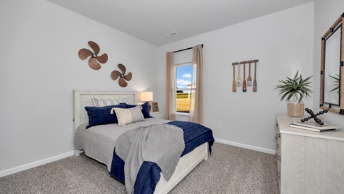 Secondary bedroom with carpet and window