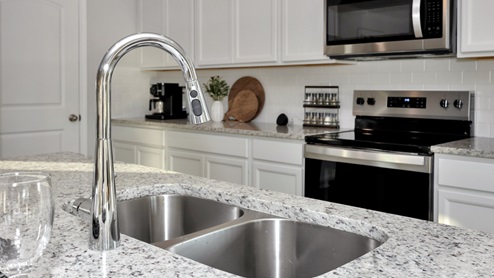 Kitchen island with painted cabinets and stainless steel appliances
