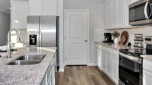 Kitchen island with painted cabinets and stainless steel appliances