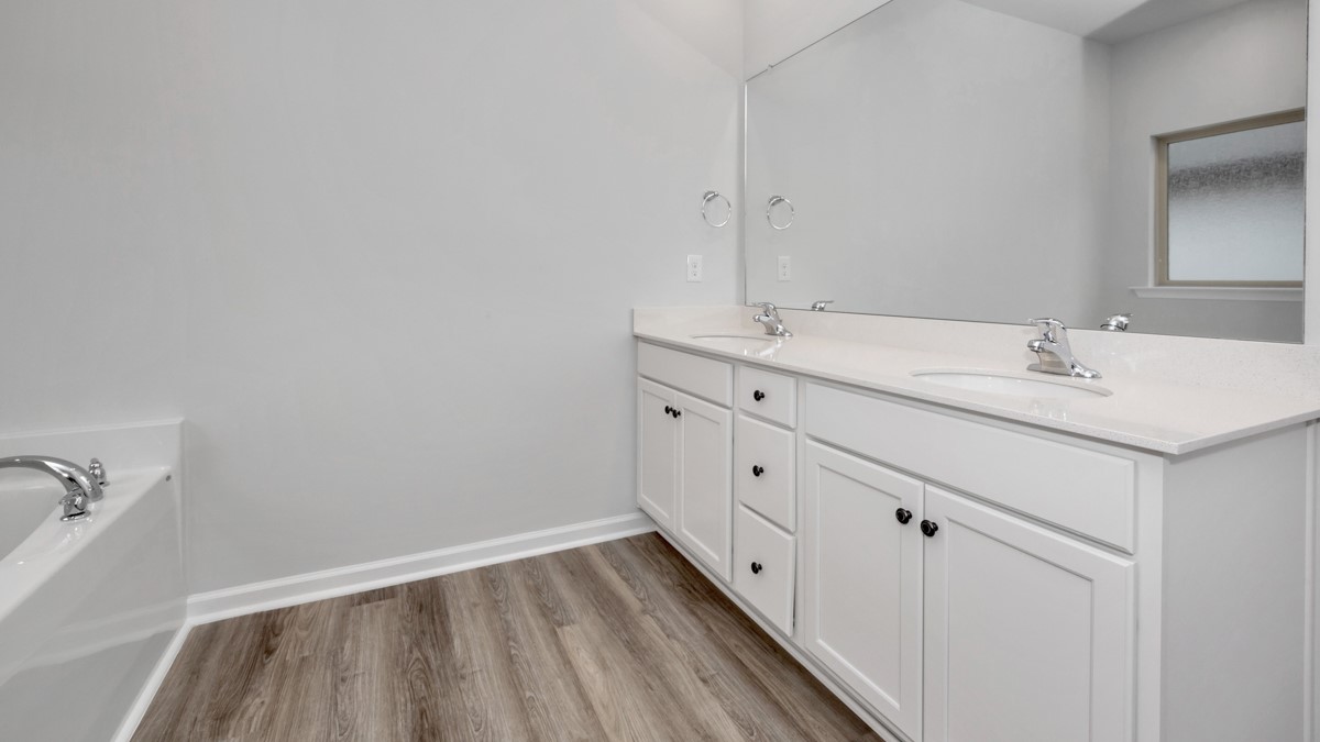 Primary bath with painted cabinets and quartz countertops