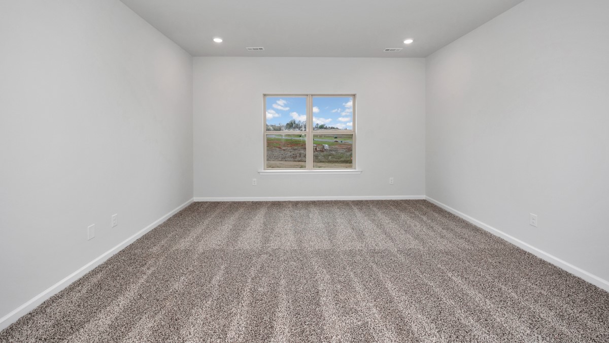 Secondary bedroom with carpet and window
