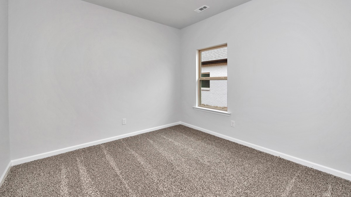 Secondary bedroom with carpet and window
