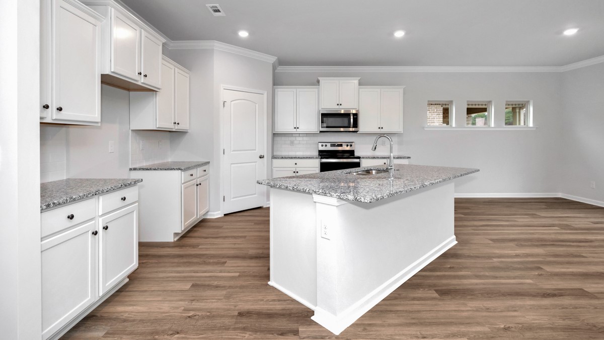 Kitchen island with painted cabinets and stainless steel appliances
