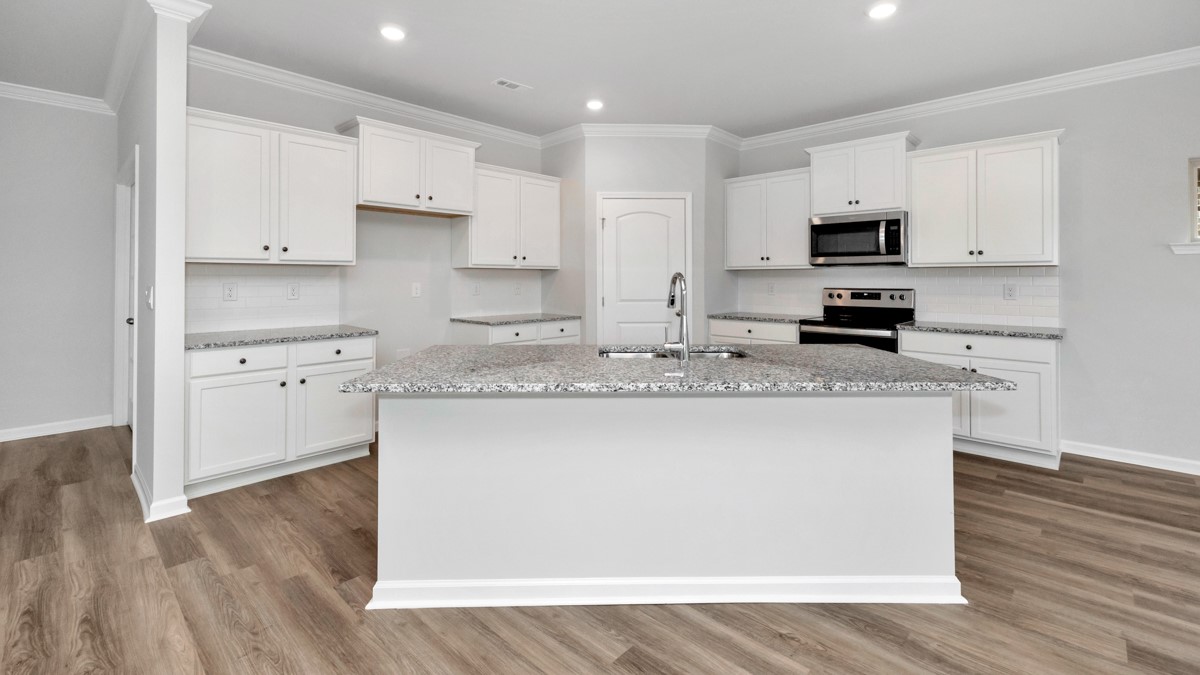 Kitchen island with painted cabinets and stainless steel appliances