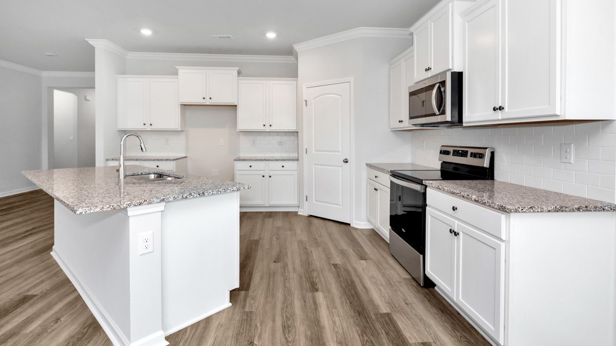 Kitchen island with painted cabinets and stainless steel appliances