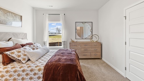 Secondary bedroom with carpet and window