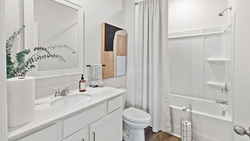 Secondary bathroom with painted cabinets and quartz countertops