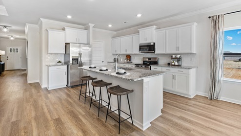 Kitchen island with painted cabinets and stainless steel appliances